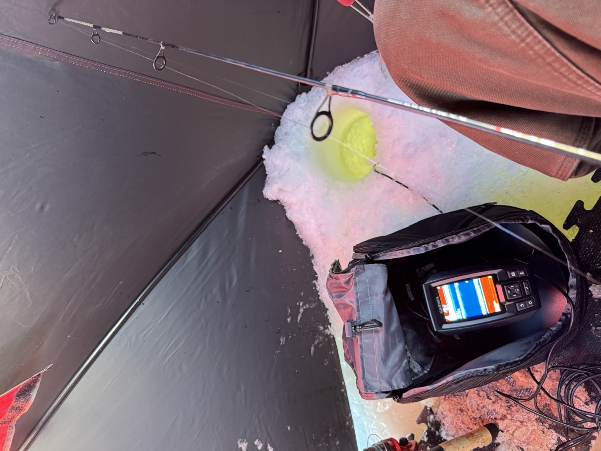 Line down the ice hole with Garmin fish finder nearby